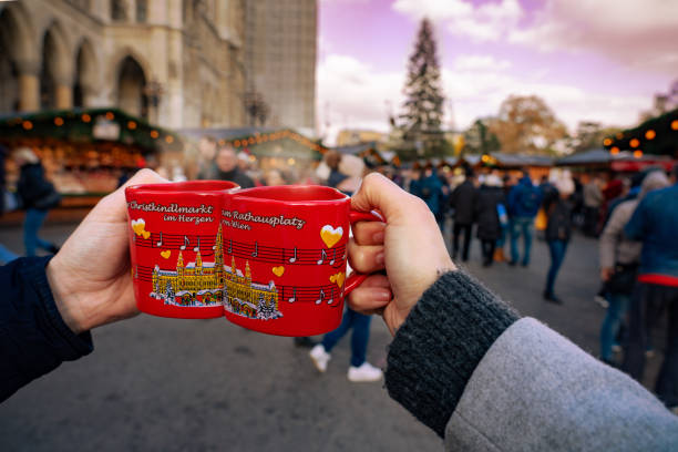 Drinking gluwein hot alcoholic spicey red wine on christmas market cups on the rathausplatz in Vienna Vienna, Austria - 11.23.2019 : Drinking gluwein hot alcoholic spicey red wine on christmas market cups on the rathausplatz in Vienna . vienna city hall stock pictures, royalty-free photos & images