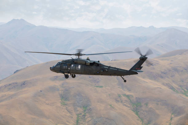 istock Army Helicopter Flies over Mountains 1189798150