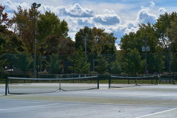 istock Tennis courts with blue surface and mesh fences 1189799328