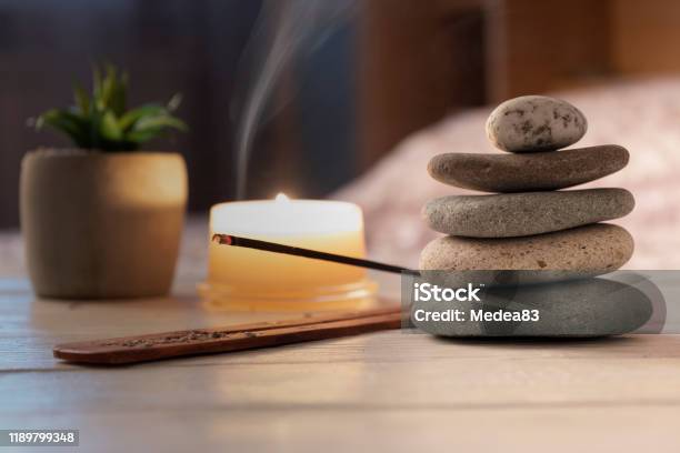 Pyramid Of Zen Stones Burning Candle Incense Stick Bedroom Interior Evening Meditation Concept Stock Photo - Download Image Now