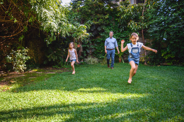 istock Father and Young Daughters Outdoors in Family Backyard 1189800703