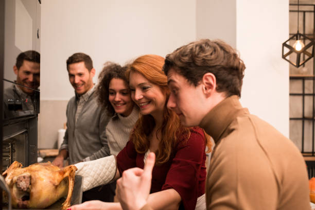 istock Happy family baking a Thanksgiving turkey 1189803410