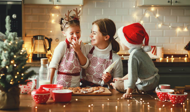 glückliche familie mutter und kinder backen weihnachtsplätzchen - plätzchen backen stock-fotos und bilder