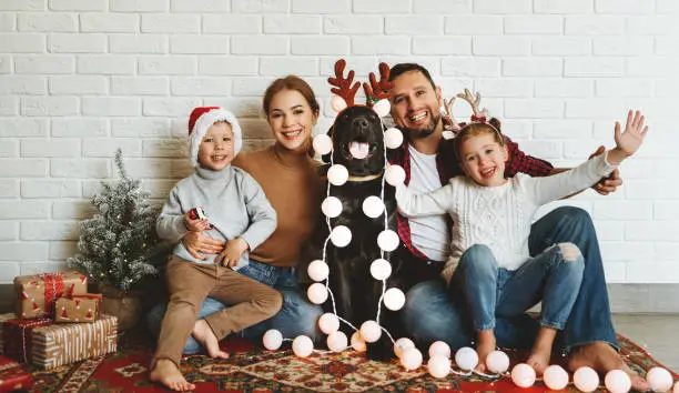 Photo of happy Christmas! family mother father and kids with dog before Christmas with garland   and tree