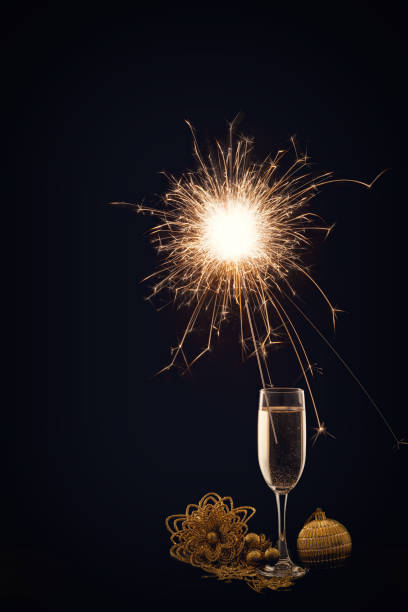 istock Champagne glass with lit sparkler against a dark background 1189806499
