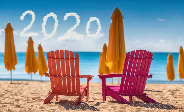 2020 Happy new year concept and two deckchairs on the beach