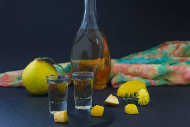 Quince brandy, strong drink in a bottle and glasses on dark background Quince brandy or quince vodka, hard liquor, strong drink in a bottle and glasses on dark background serbian raki stock pictures, royalty-free photos & images