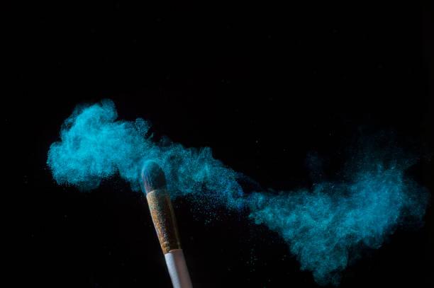 istock Make-up brush with blue powder explosion isolated on black background 1189809063
