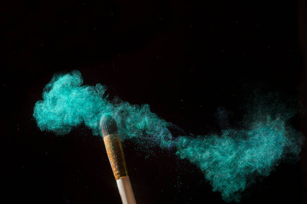 istock Make-up brush with green powder explosion isolated on black background 1189809114