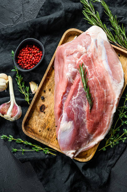 istock fresh pork cuts. Raw meat with spices.   shoulder butt part.. Black background. Top view 1189810115
