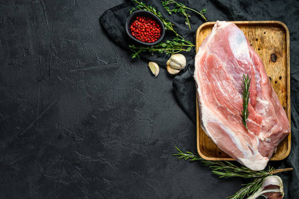 istock fresh pork cuts. Raw meat with spices. Black background. Top view. Space for text 1189810581