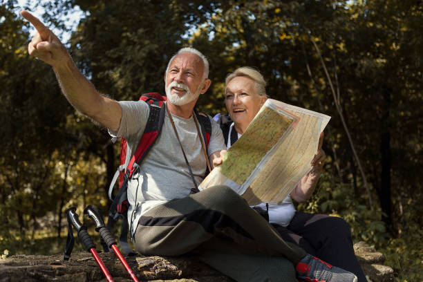 istock Senior hiker looking at hiking map showing a path 1189811491