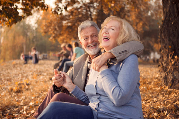 istock Romantic mature couple sitting in park smiling 1189811512