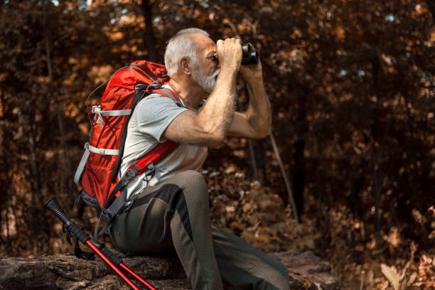 istock Tired Senior man resting after hiking using binoculars 1189811613