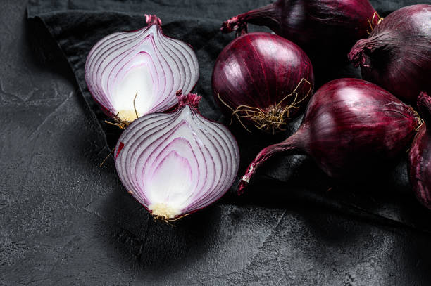 istock Red onion, onion halves. Black background. Top view. 1189811766