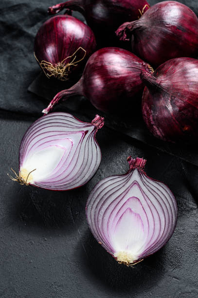 istock Red onion, onion halves. Black background. Top view. 1189811785