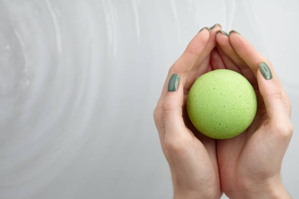 istock Woman's hand putting bath bomb into water 1189812693