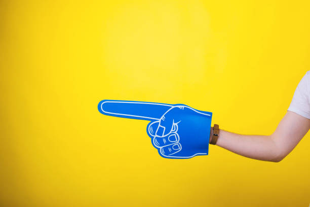 istock Fan finger foam pointing at copyspace over yellow background 1189814883