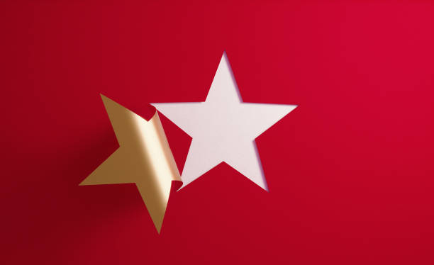 A golden star shape folding on red background.  Horizontal composition with  copy space.