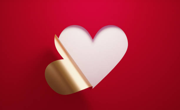 el concepto del día de valenténe- una forma de corazón dorado plegable sobre fondo rojo - beautiful romance love elegance fotografías e imágenes de stock