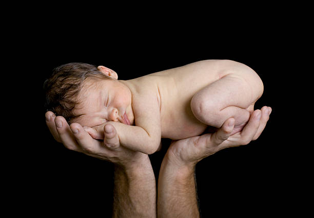 istock Newborn Baby Raised Up in Father's Hands 118982435
