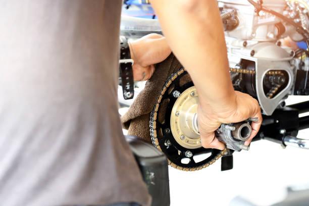 Man cleaning the chains in the engine automotive, as background. Object or transportation concept.