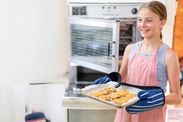 Girl Getting Homemade Chocolate Chip Cookies From the Oven