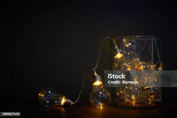 Glass Vase Filled With Luminous Bulbs On A Wooden Table Holiday Concept Stock Photo - Download Image Now
