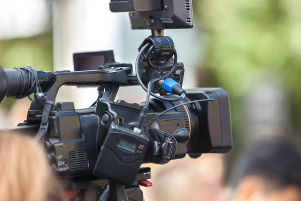 istock Man journalist with a modern large black video camera 1189828593