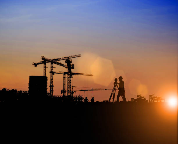 istock Silhouette of Survey Engineer and construction team working at site over blurred  industry background with Light fair Film Grain effect.Create from multiple reference images together 1189829550
