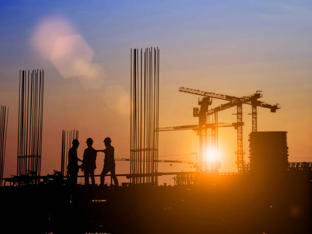 istock Silhouette of Survey Engineer and construction team working at site over blurred  industry background with Light fair Film Grain effect.Create from multiple reference images together 1189829552