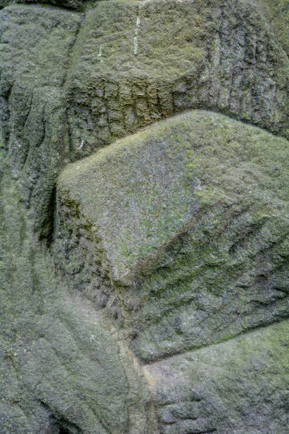 istock Ancient, weathered carved stone blocks. Decorative masonry overgrown, green moss 1189830915