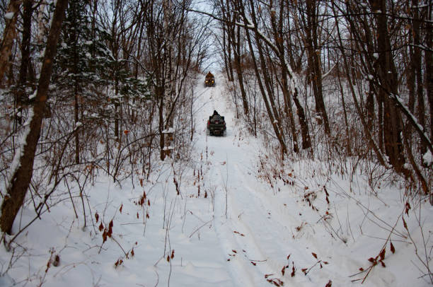 istock Two ATVs on wheels with headlights on ride through a snowy forest. 1189832240