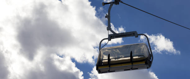 chair-lift and sunlit sky with clouds at evening - telpher imagens e fotografias de stock