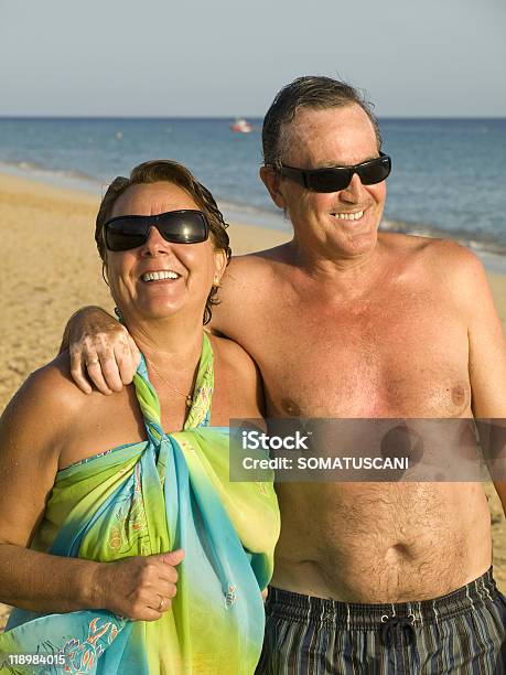 Coppia Senior Divertendosi In Spiaggia - Fotografie stock e altre immagini di A petto nudo - A petto nudo, Adulto in età matura, Marito