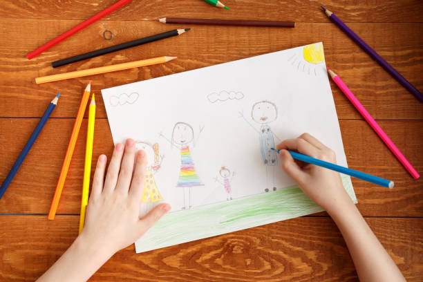 istock Character Child Drawing Image on Wooden Table 1189850515