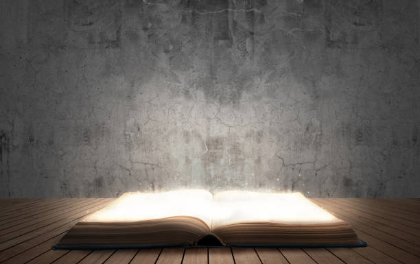 open illuminated big book on wooden floor