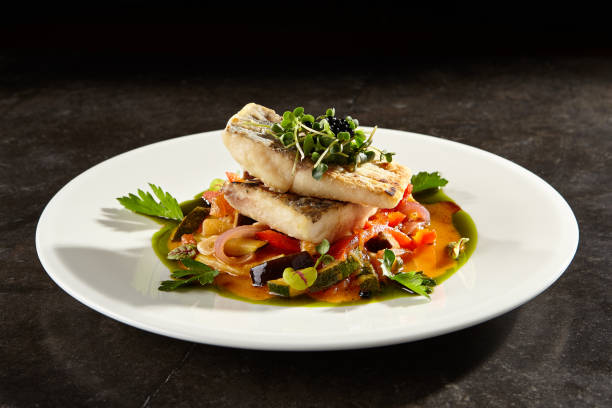 istock Pollock fish fillet with vegetables on white plate 1189853640