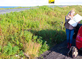 Iceland Road Trip: Senior Woman Studying Paper Map Roadside