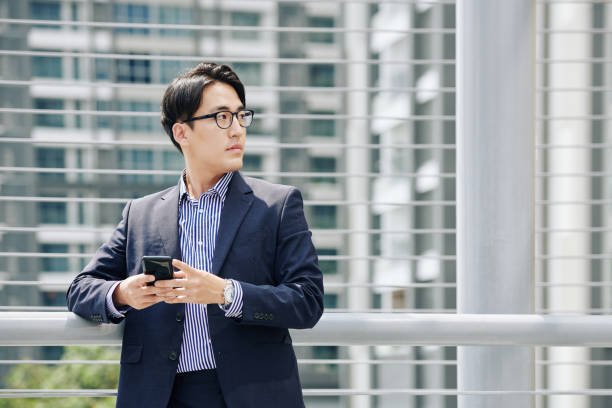 istock Confident businessman with smartphone 1189861874