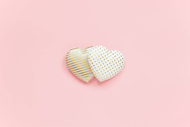istock Two textile hearts with golden pattern on pink background, central composition, minimal style. Concept love, relationships. Template for Valentine card, wedding invitation and greeting card 1189863572