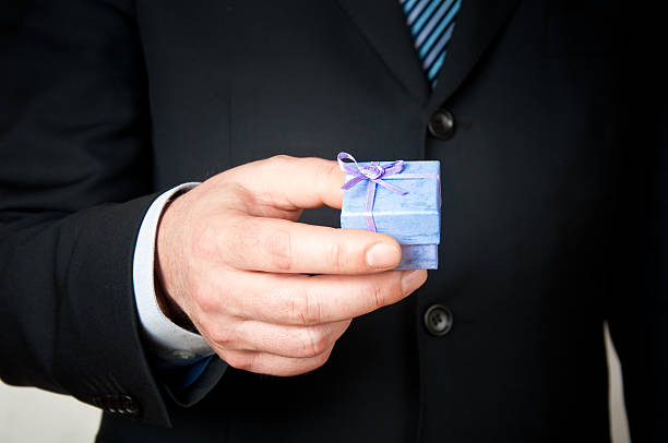 istock Businessman holding a small blue  gift box 118986661