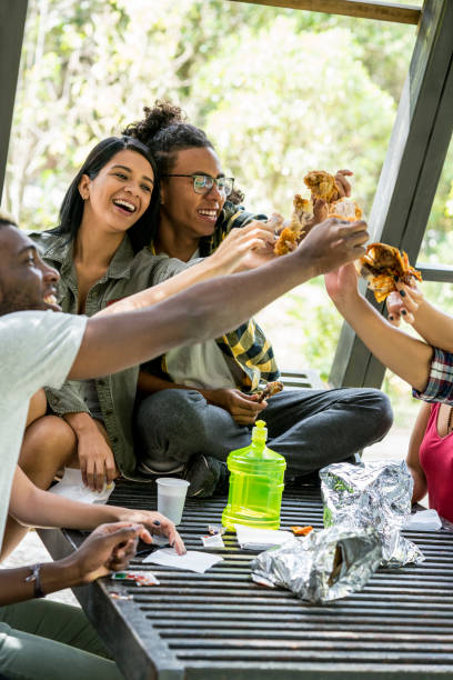 istock Friends laughing while sharing a fried chicken lunch outdoors 1189871048