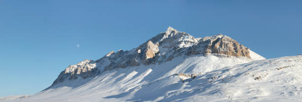 istock Mountain covered by snow with moon in the sky 1189871258