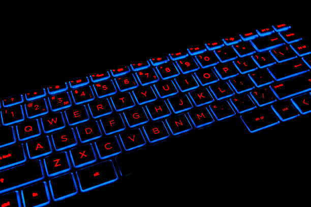 istock Close up view of a modern laptop computer keyboard keys. Soft lightning in red tones. Pc computer keyboard close up 1189873641