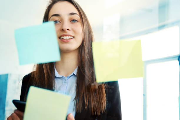 istock Business woman with digital tablet looking at sticky notes 1189878578