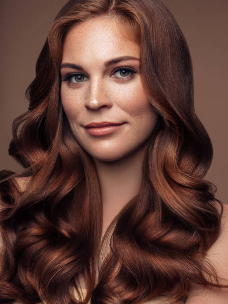 modelo bonito novo com cabelo bem preparado ondulado longo - cabelo pintado de vermelho - fotografias e filmes do acervo