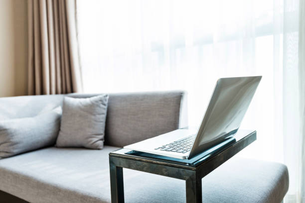istock Laptop on table near gray sofa 1189884690