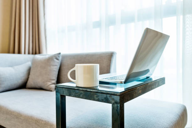 Laptop on table near gray sofa