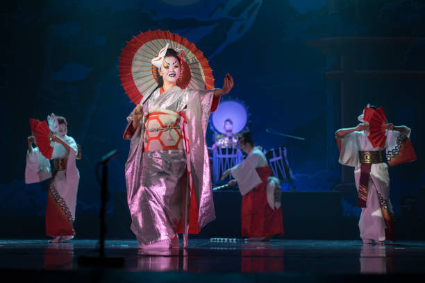 traditionelle japanische aufführung. schauspielerinnen in traditionellen weißen und roten kimono- und fuchsmasken tanzen mit regenschirm und fans. - unterhaltungsberuf stock-fotos und bilder